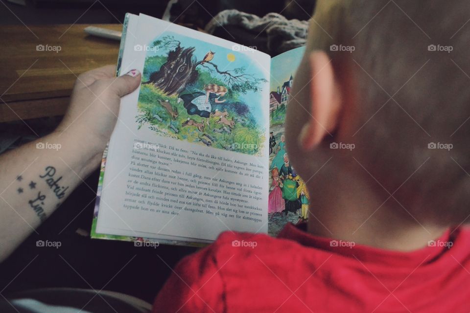 Rear view of boy reading story book