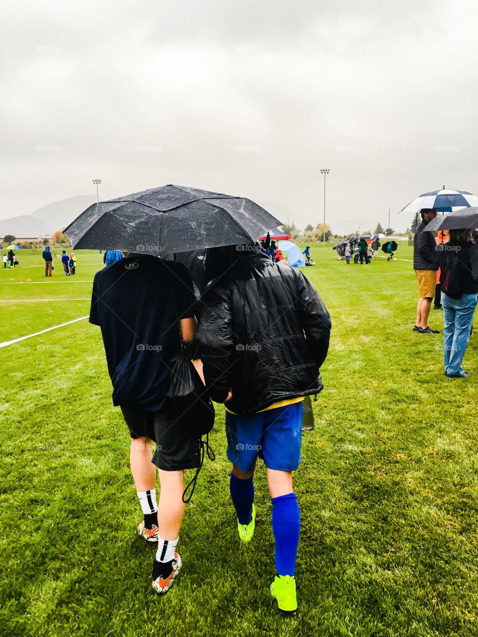 Sharing an umbrella after soccer game