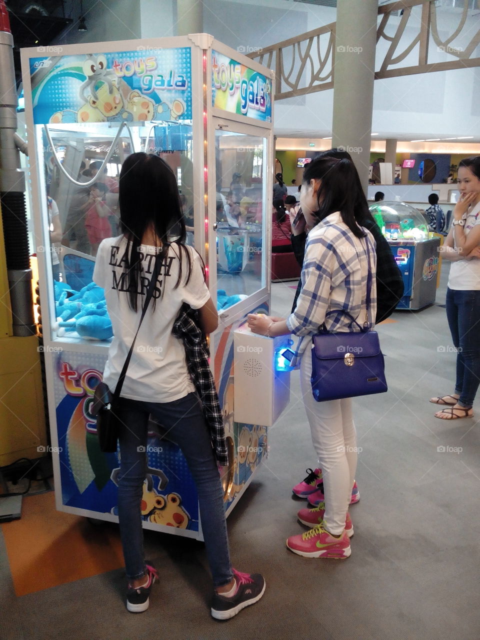 trying luck game at fun fair. girl playing crane to win toy