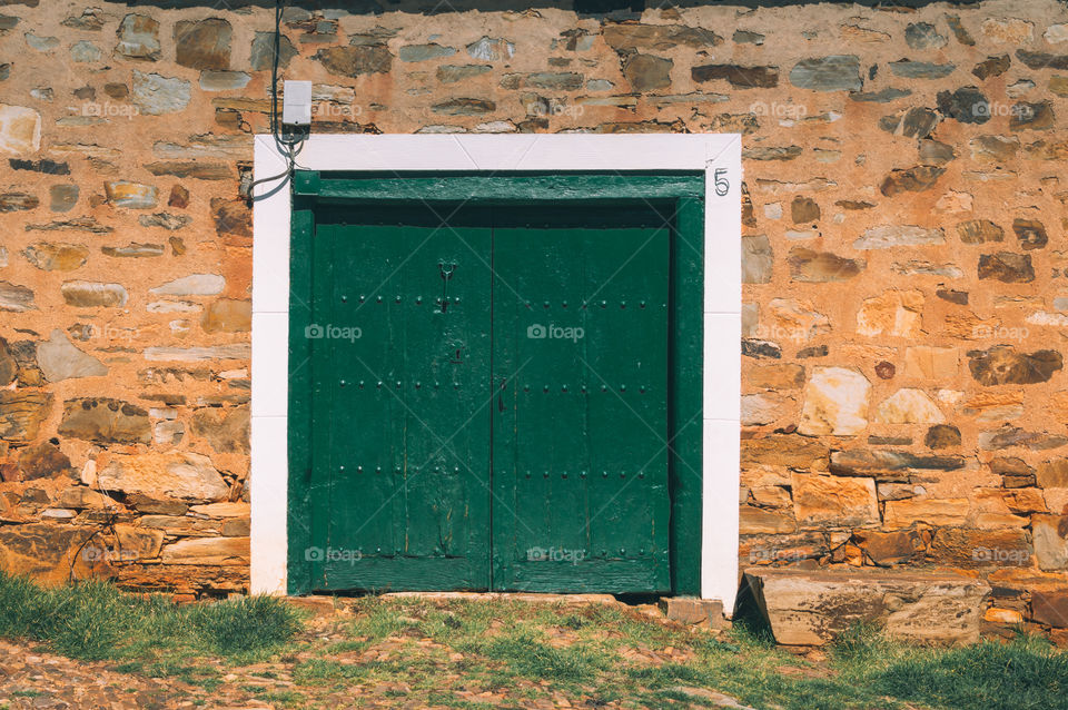 Green painted wooden door in a small village