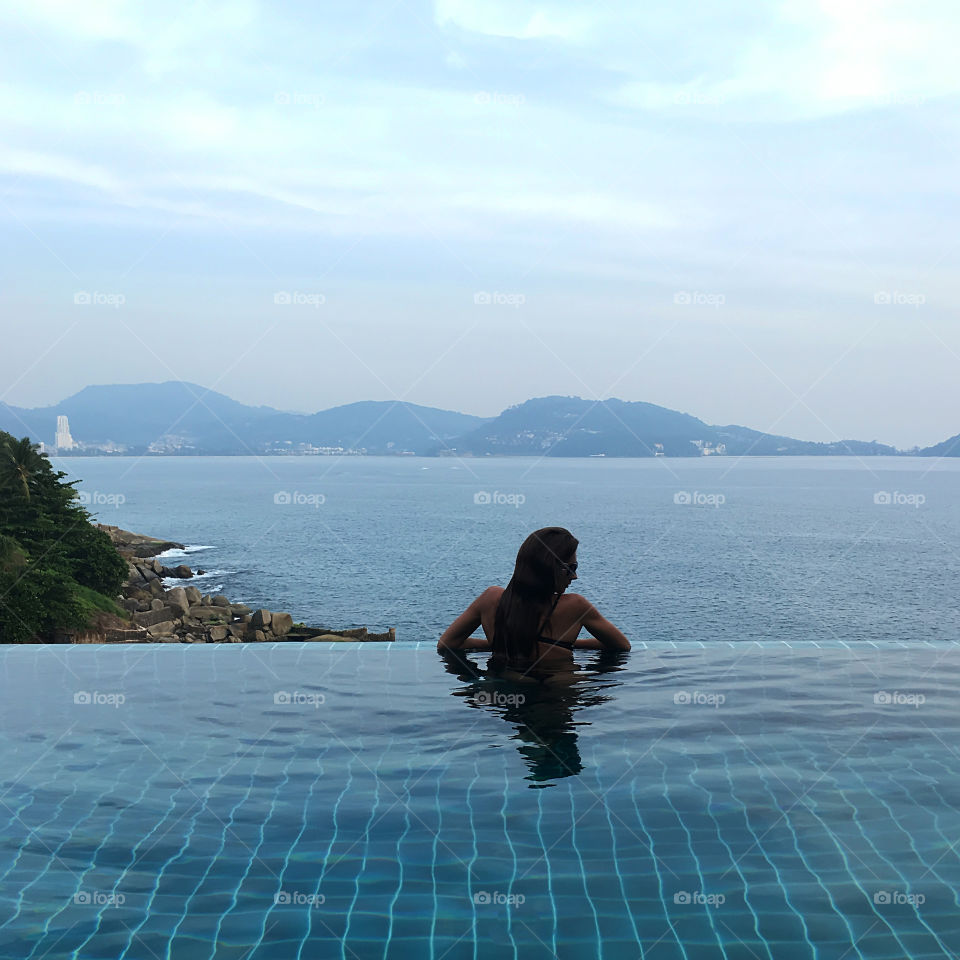 Enjoying the last summer days in the swimming pool above the sea 