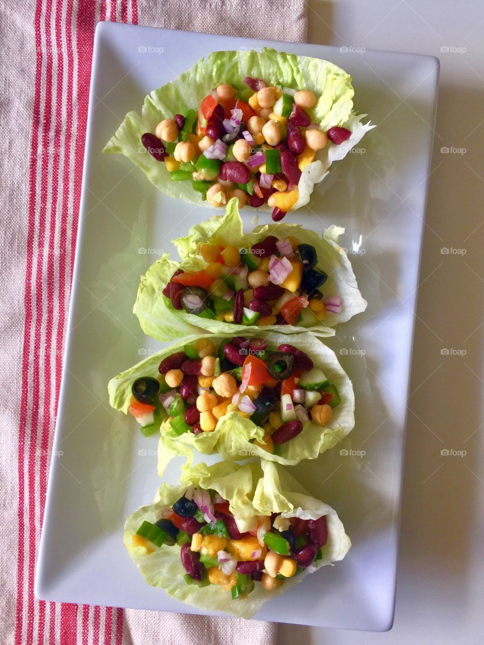 Chickpea, kidney beans and mango salad served in lettuce boats 