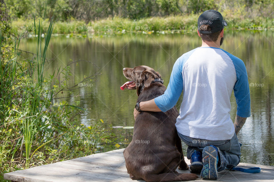 Pet time sitting with chocolate lab enjoying nature