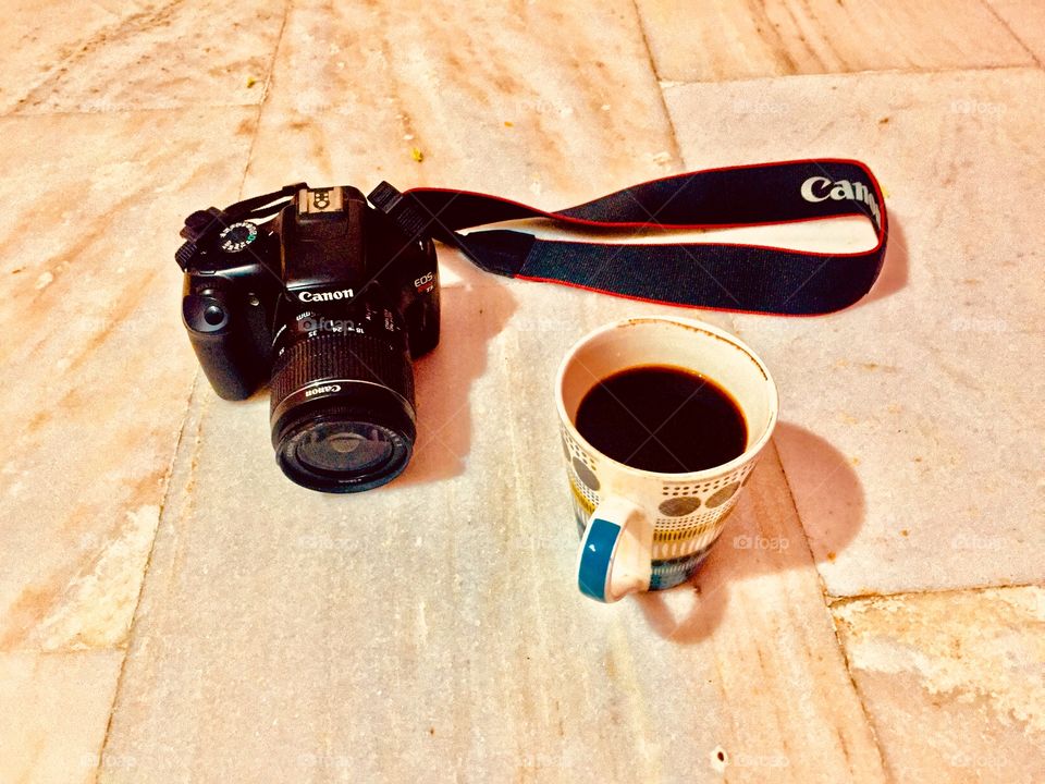 Canon DSLR Camera on the table with coffee..