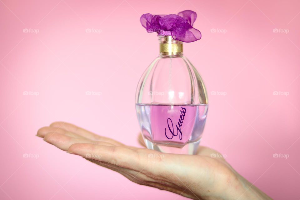 Hand holding Guess parfume