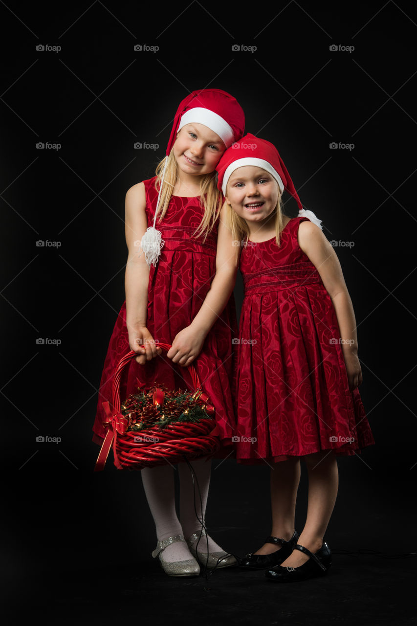 Two sisters posing for christmas portrait.