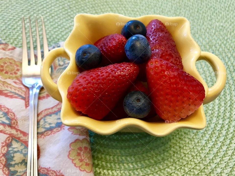 Serving of strawberries and blueberries in a fluted bowl 