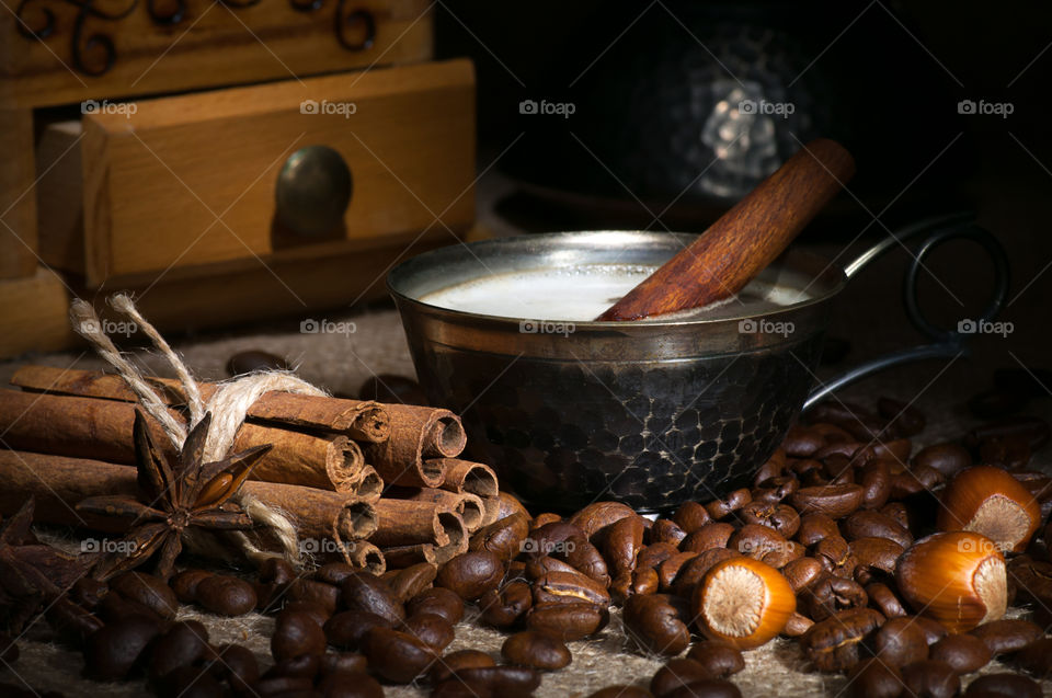 Cup of coffee served with cinnamon stick, light brush