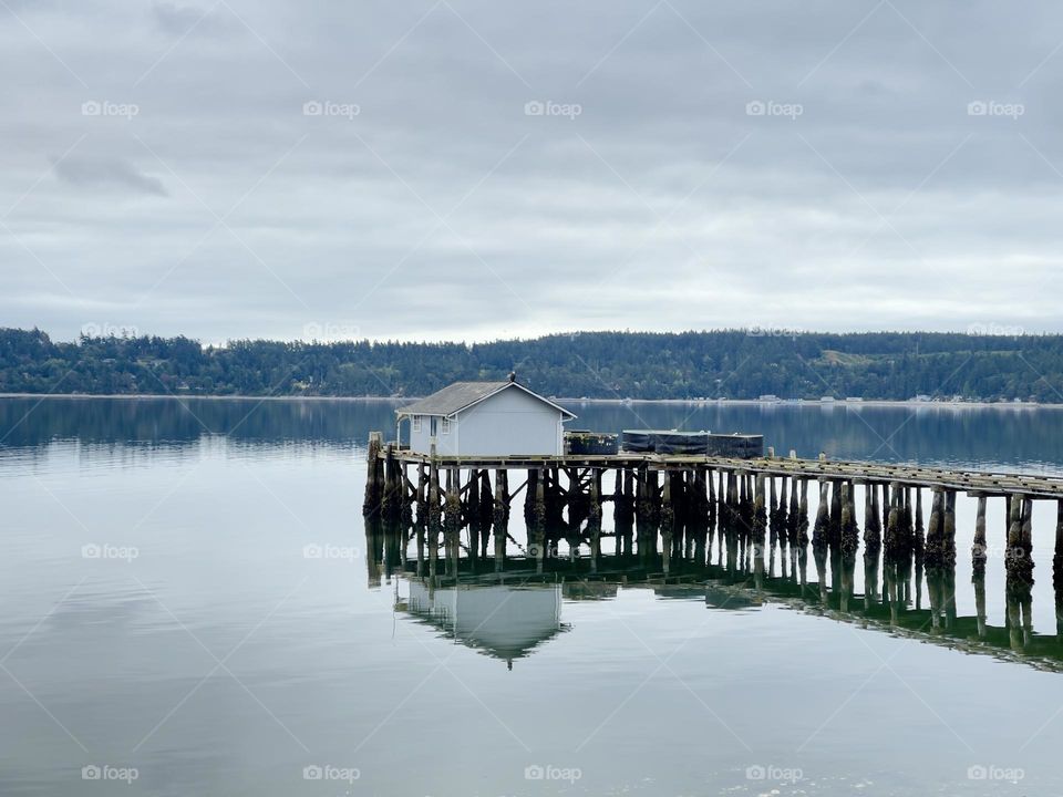 Wooden pier with the house on the lake 