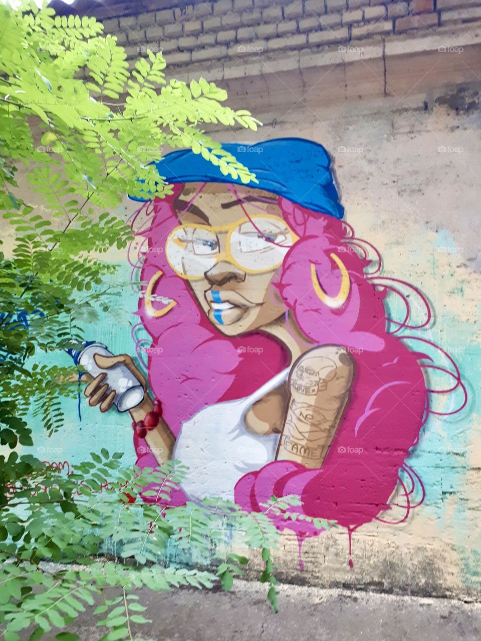 Graffiti of girl with blue hat and pink hair 