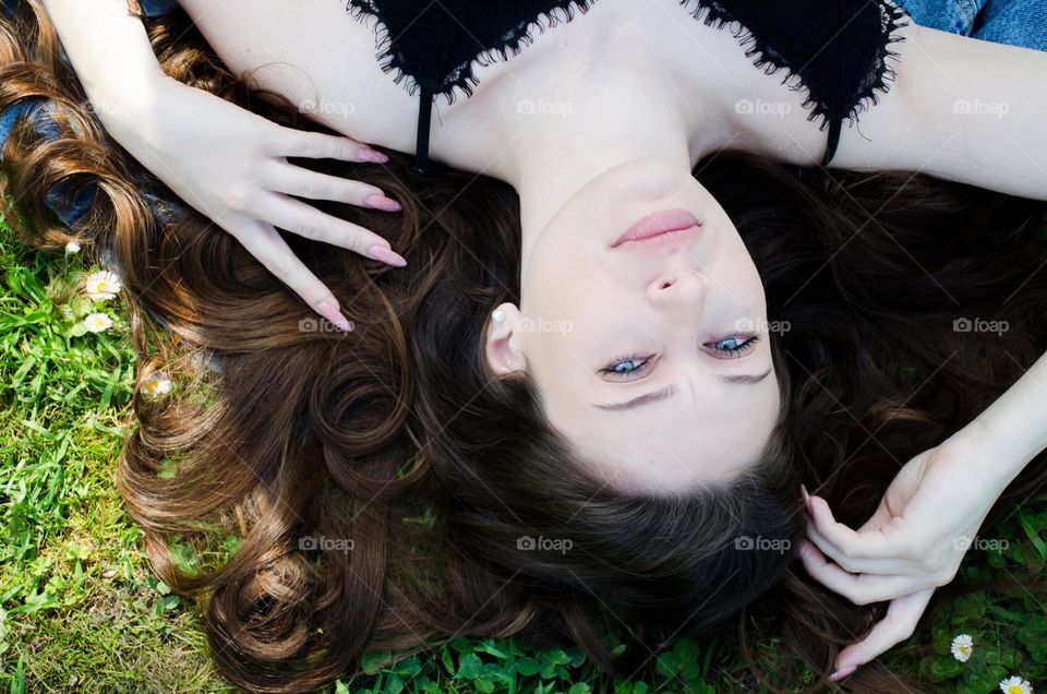 Portrait of a Beautiful Young Girl on Background of Daisies