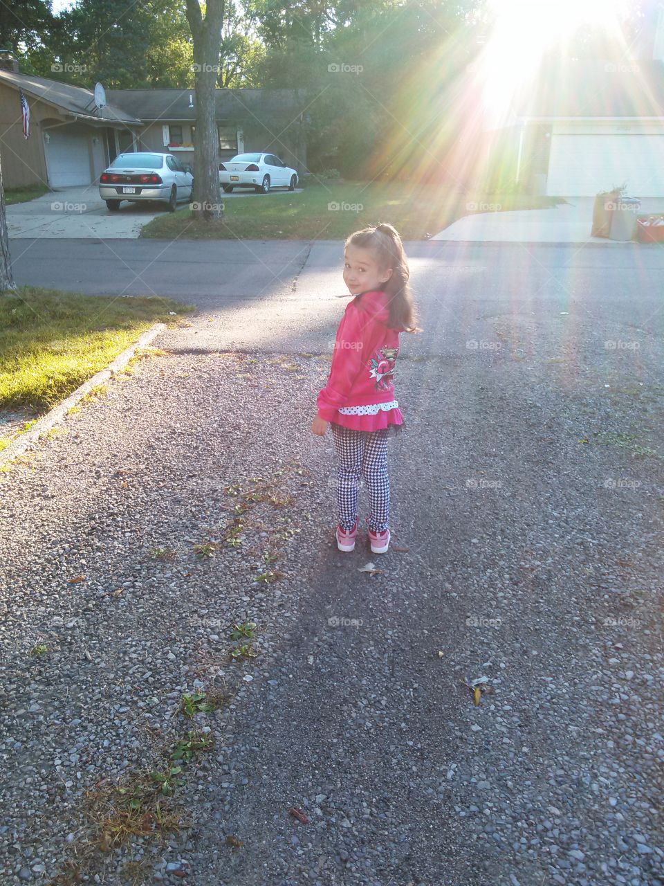 Look Over Your Shoulder Honey. little girl, looking over her shoulder in the bright morning sun