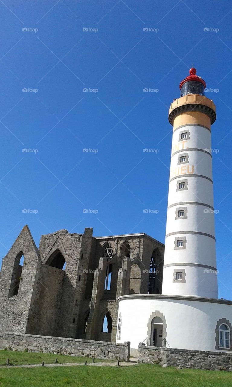 Close up of the lighthouse and the abbey of Saint Mathieu in Plougonvelin under a bright blue sky