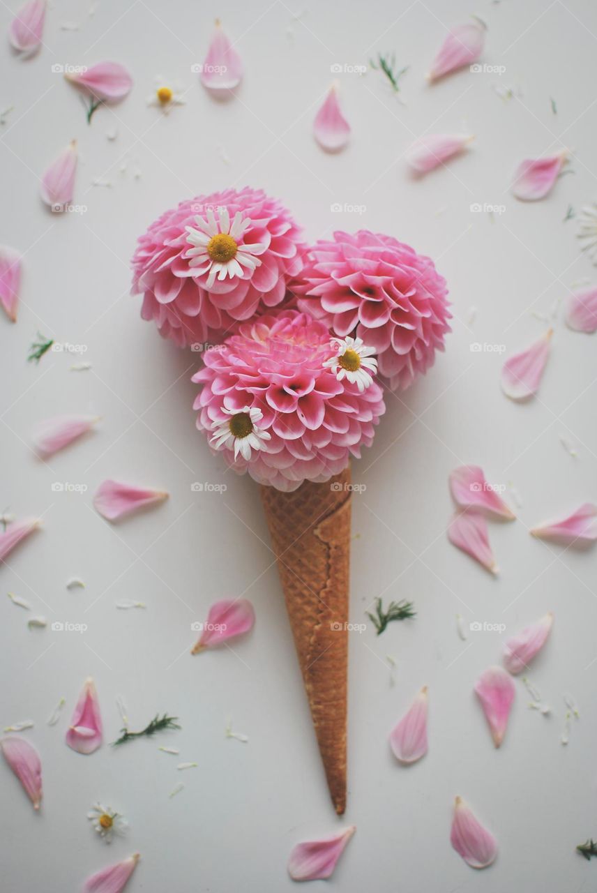 Ice-cream cône with dahlia flowers and daisies