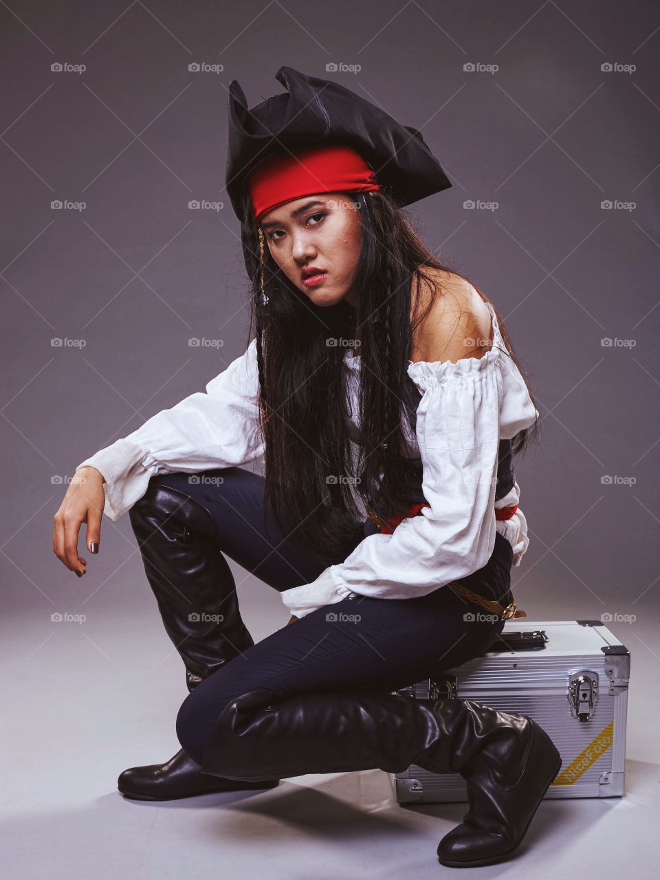 Woman in pirate costume sitting on a box 