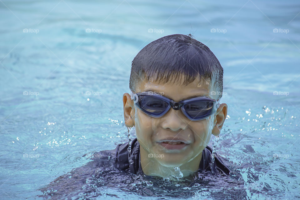 Asian boy learned to swim in the pool.