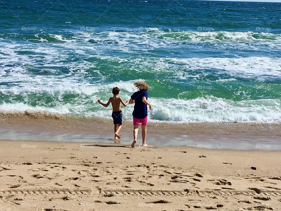 Kids running into the surf, Asbury Park, NJ