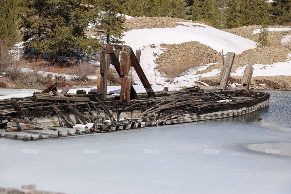 An abandoned gold mining dredge, frozen in a mountain lake in Colorado. 