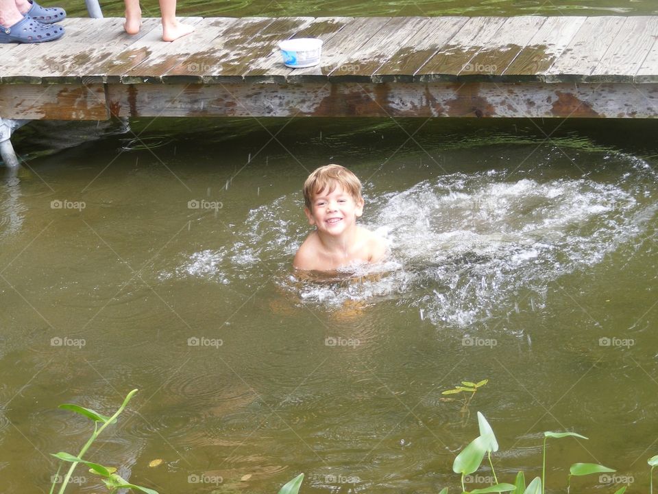 This boy just jumped off a pier and into the water.