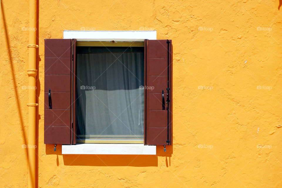 Window with yellow wall in burano, italy