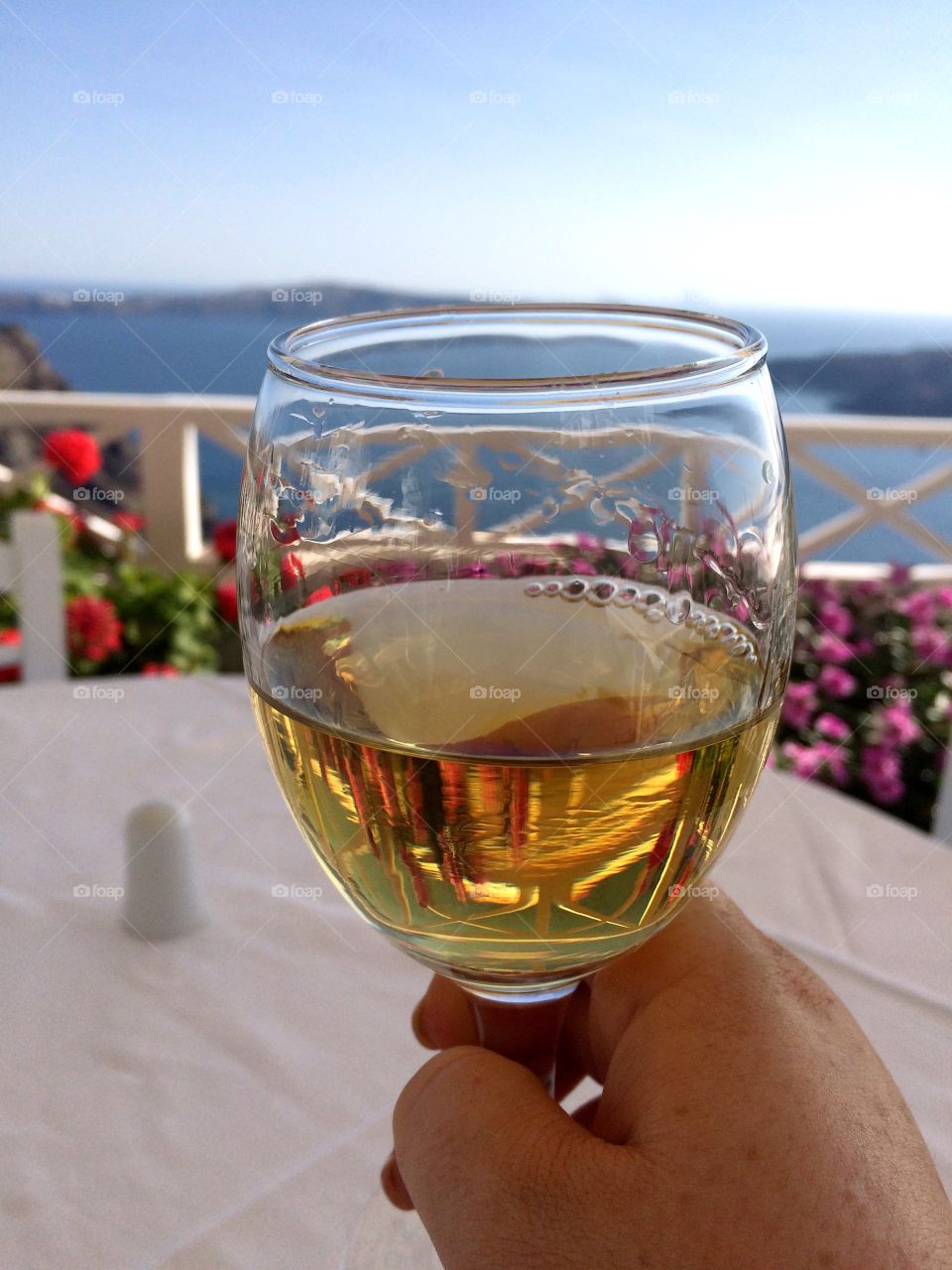 Woman holding a glass of wine with a backdrop of the ocean