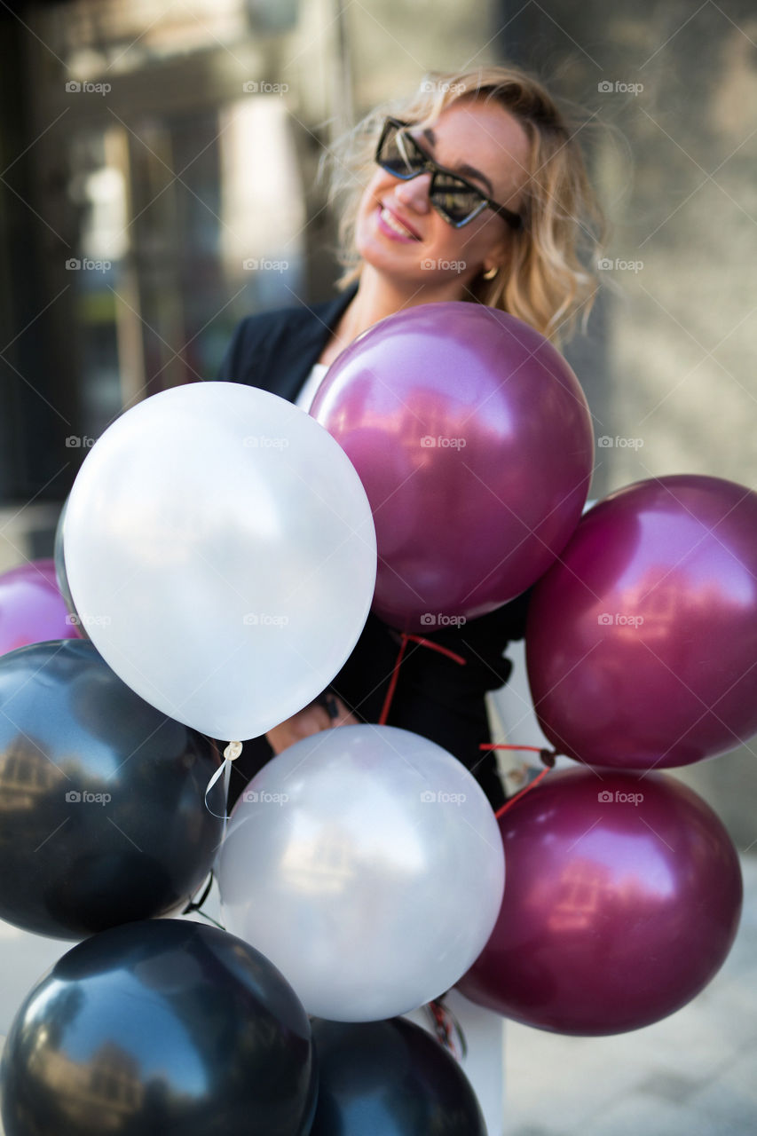 Happy sexy blond girl. Birthday girl. Girl walk at street with balloons 