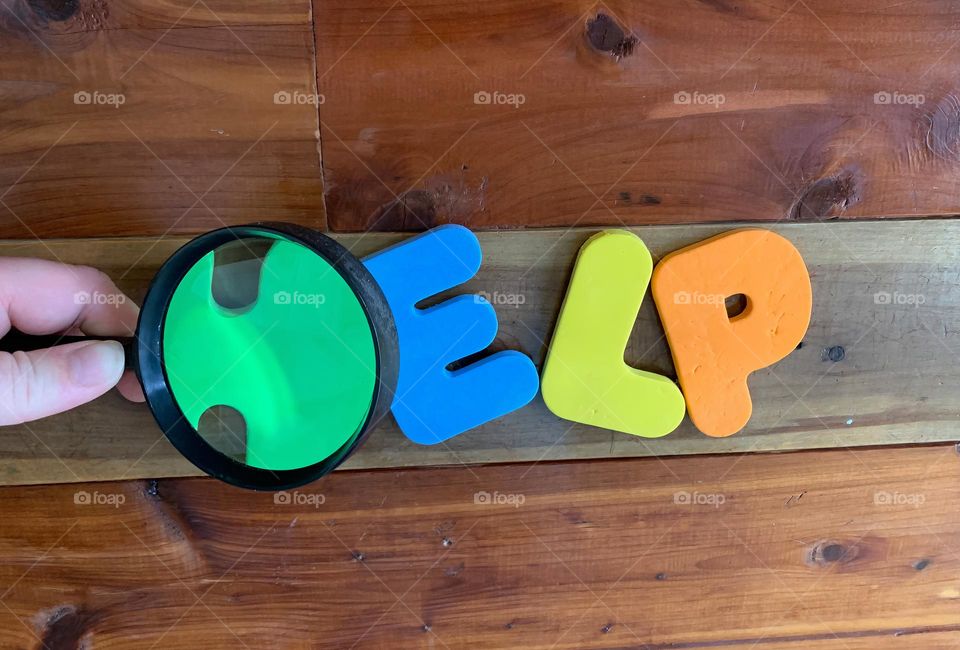 HELP Word, Colorful Kids Letterings On Wooden Wall With The Letter H Magnified Sideways