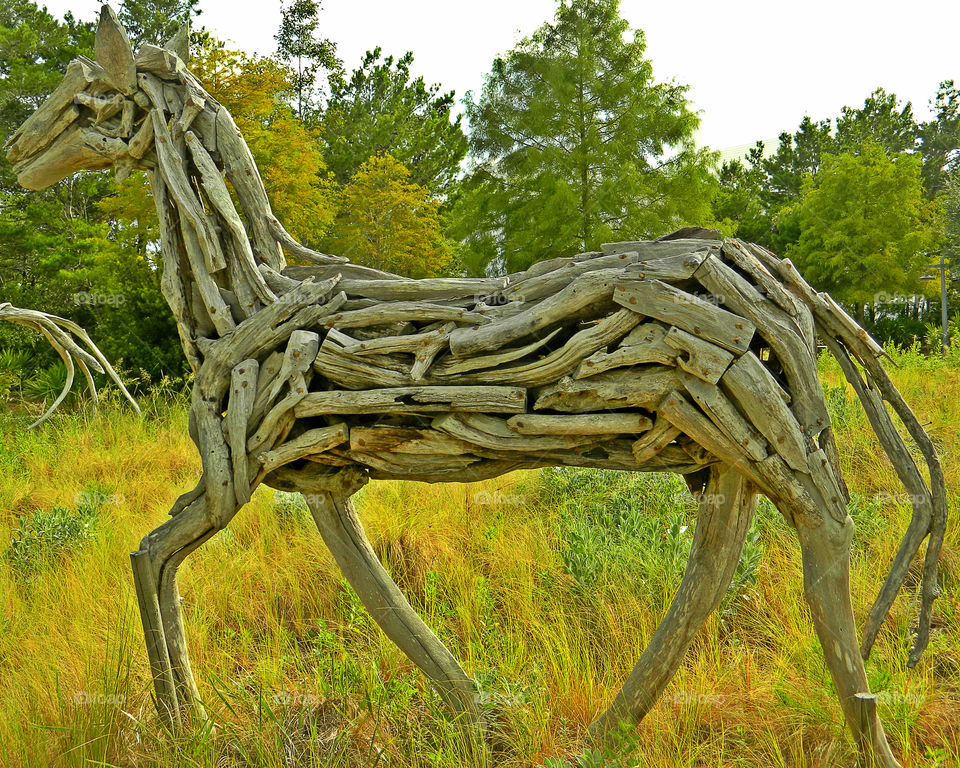 Wooden sculpture horse in forest