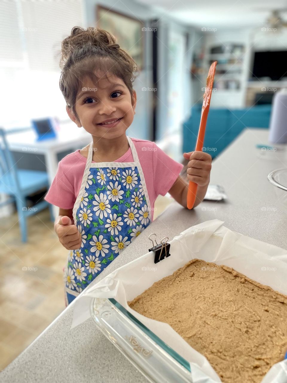 Little girl helps mommy in the kitchen, eating homemade baked goods, making delicious desserts at home, making Reese’s No Bake Bars with mommy 