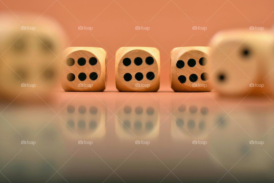 Wooden dices reflected in glass surface