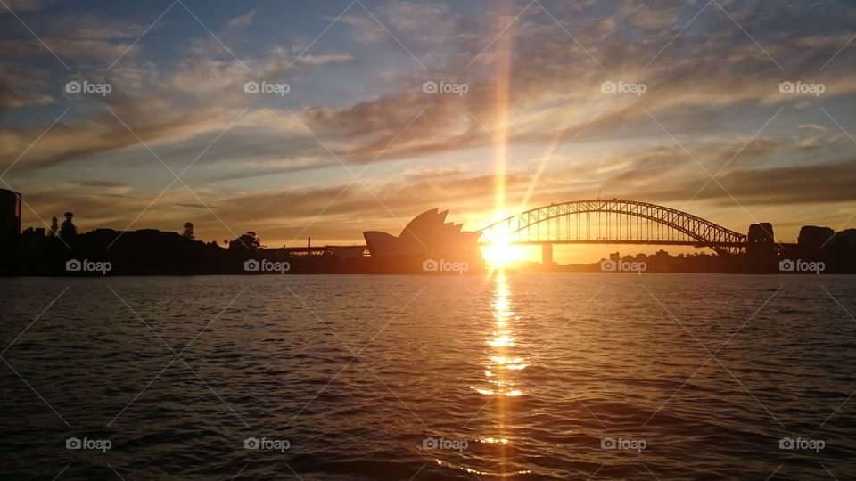 Sunset in Sydney. The sun going down behind the Harbour Bridge and the Opéra House in Sydney Australia
