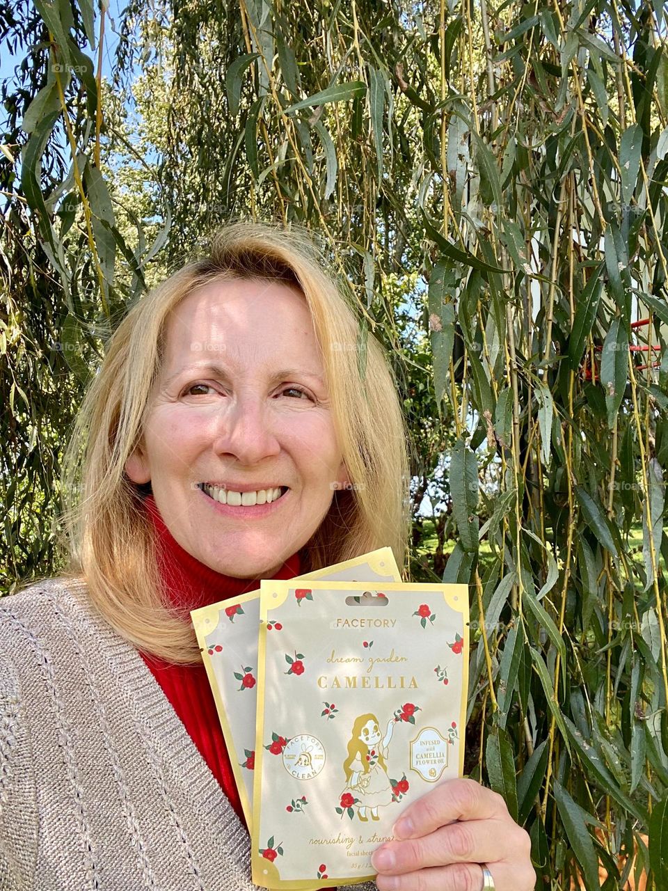 Woman with blonde hair holding a product 