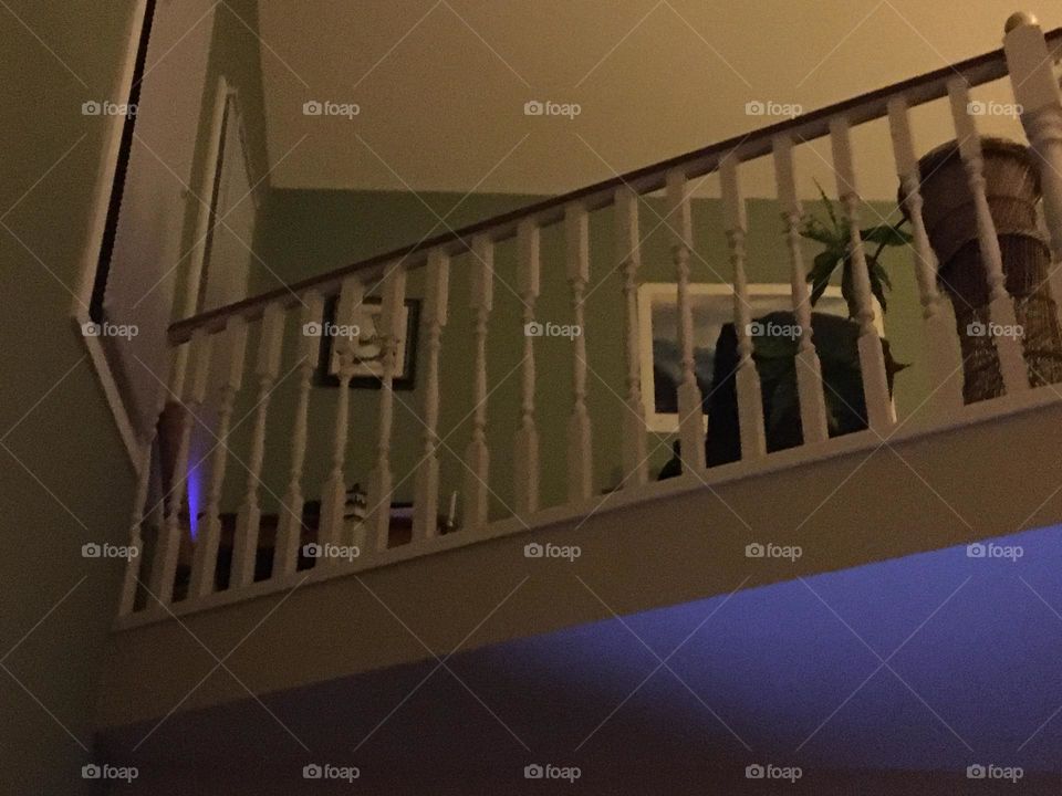 White Wood spindles and brown wood rail on the upper floor of this dark bilevel house, keeps the humans and fur babies from falling down, shows a nice little office space