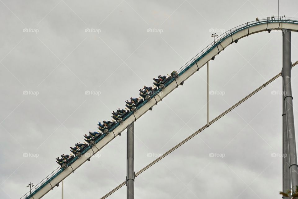 Roller coaster climbing in a cloudy day