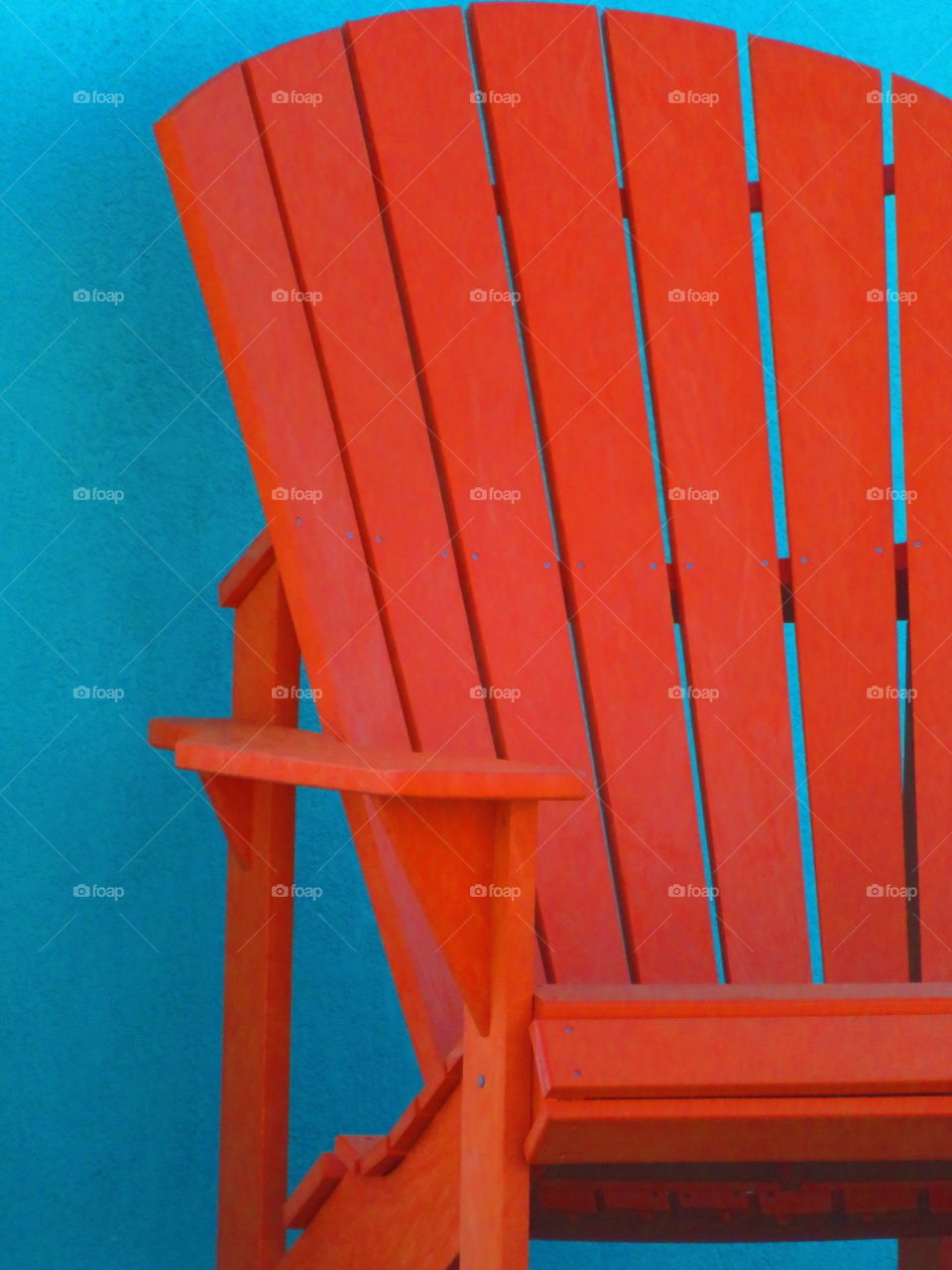 Orange adirondack chair against wall