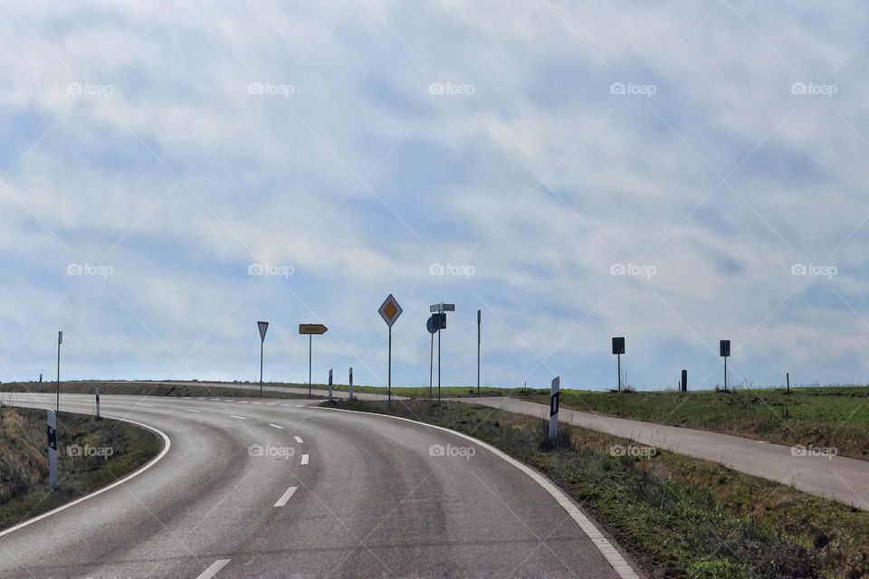 View from a moving car onto an empty country road with many traffic signs