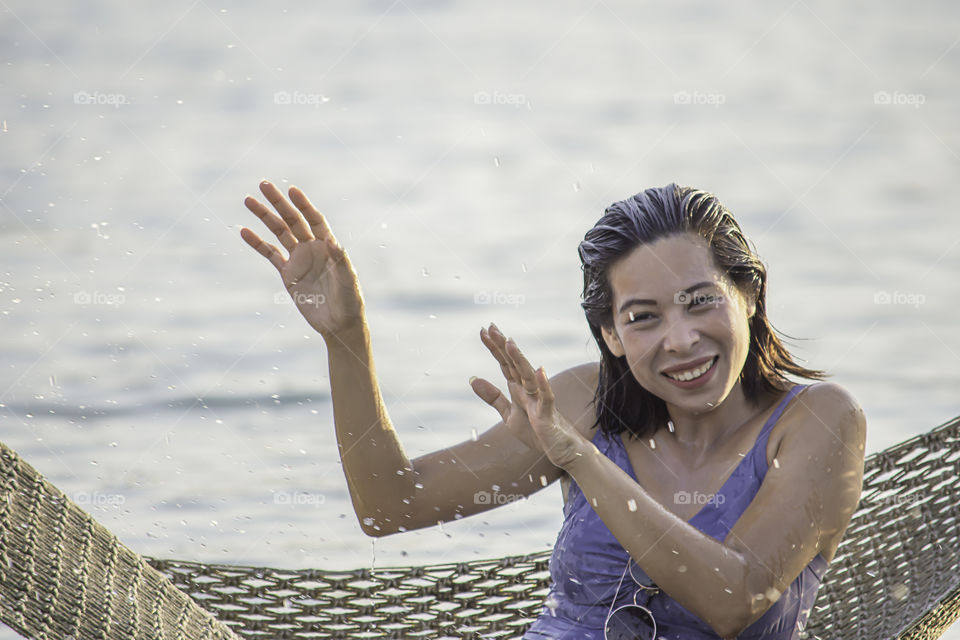 Portrait of Asian woman wearing a swimsuit on Hammock swing in sea.