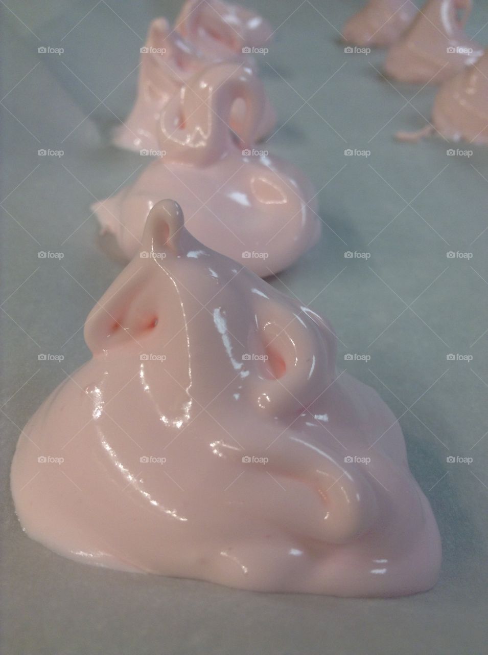 Pink meringues are on the baking tray