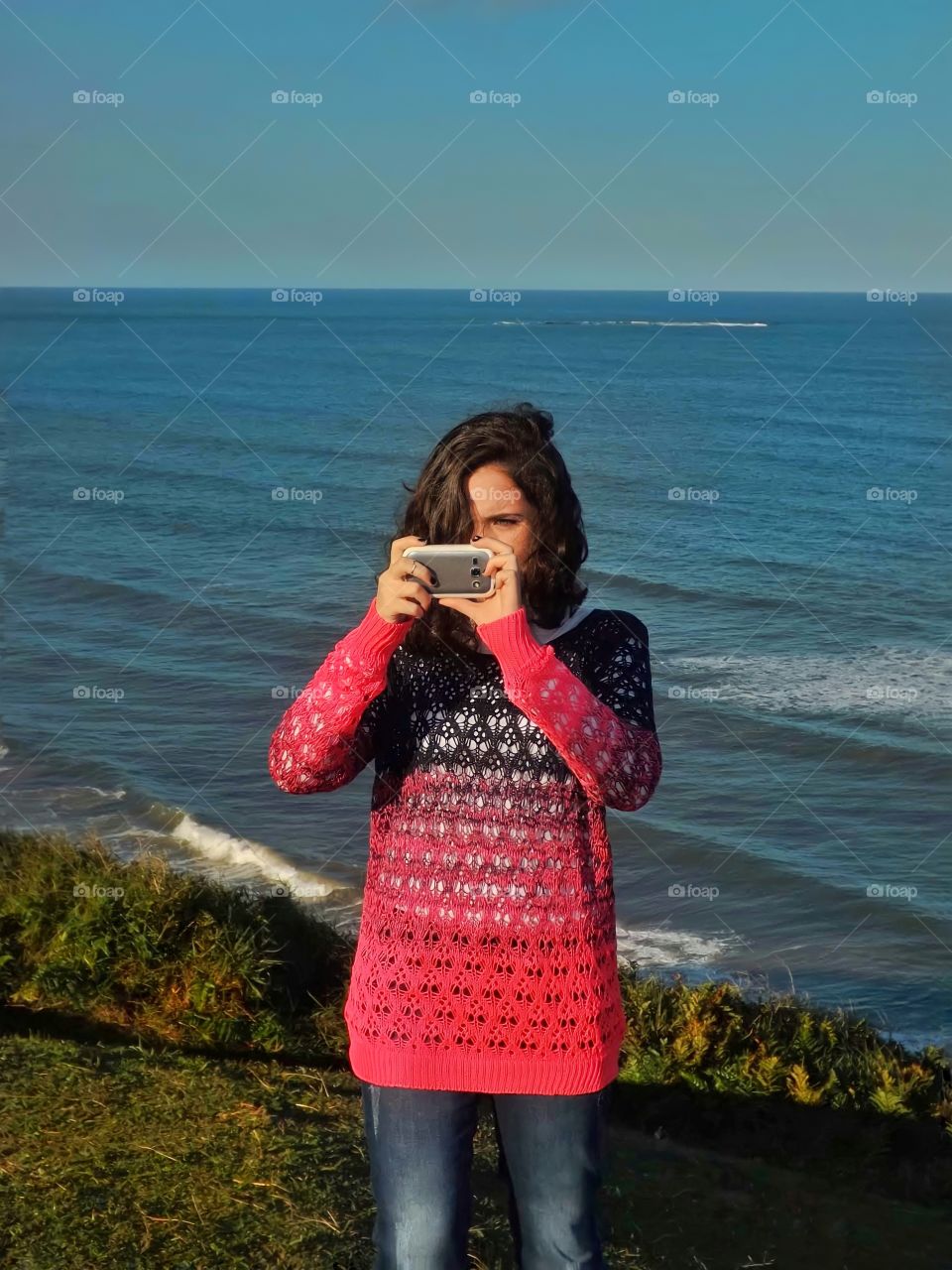 Girl photographing on the seashore