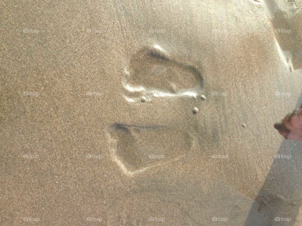 huellas de bebé en arena de mar