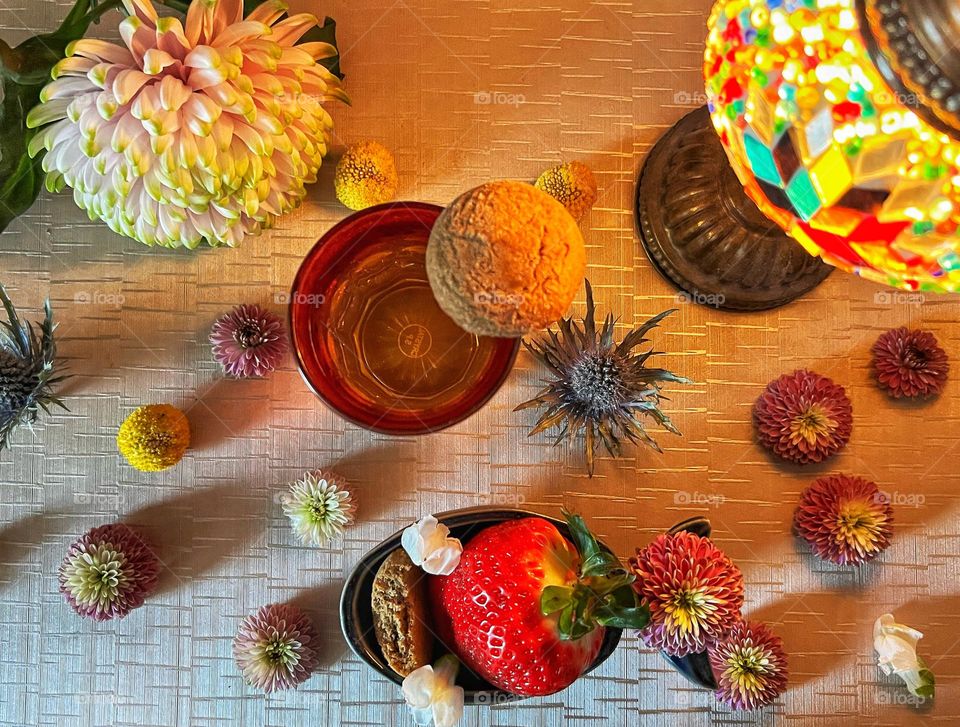 Moroccan cookies with mint tee, flowers, strawberry and light.