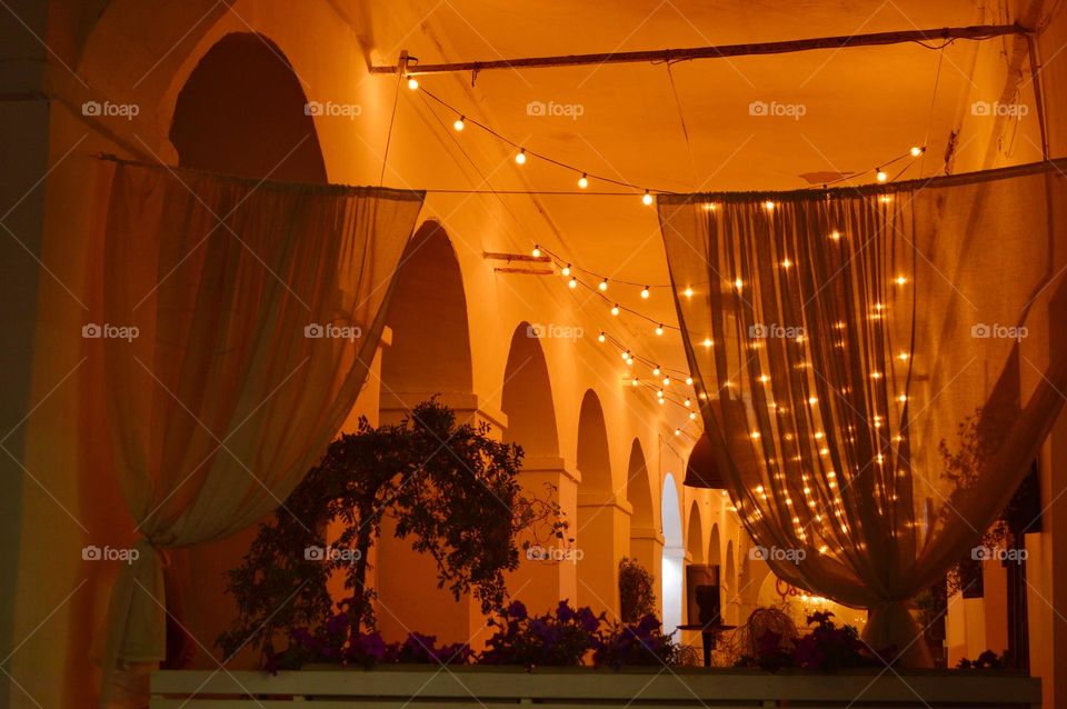 arched windows in a summer cafe decorated with plants and garland lights