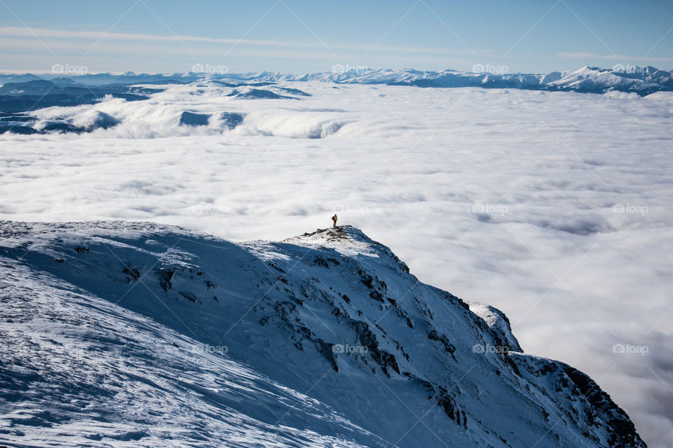 Man standing on the edge of the mountain, admiring the breaktaking view