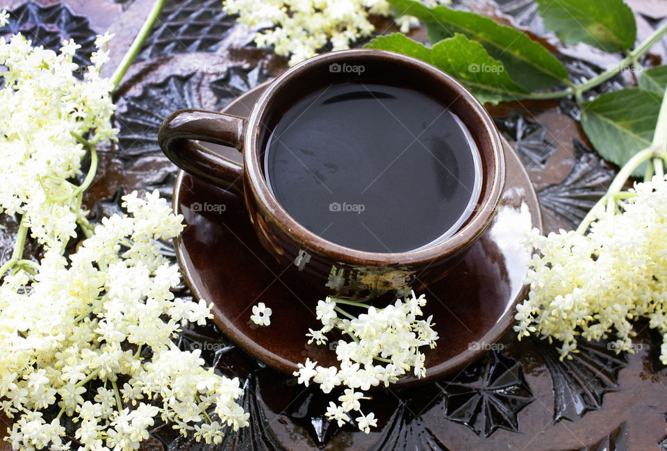 Coffee cup on a wood-carved table and elder.