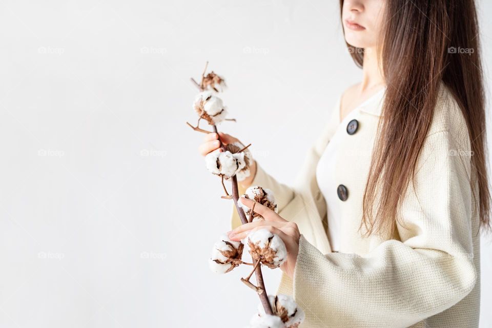 woman holding cotton branch