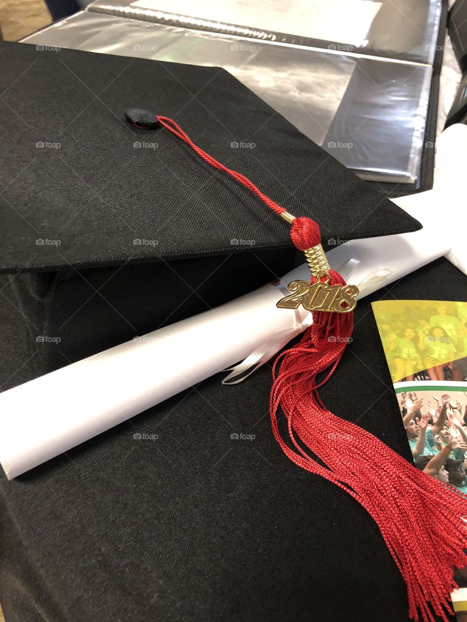 Black graduation hat with red tassel and white diploma for class of 2018