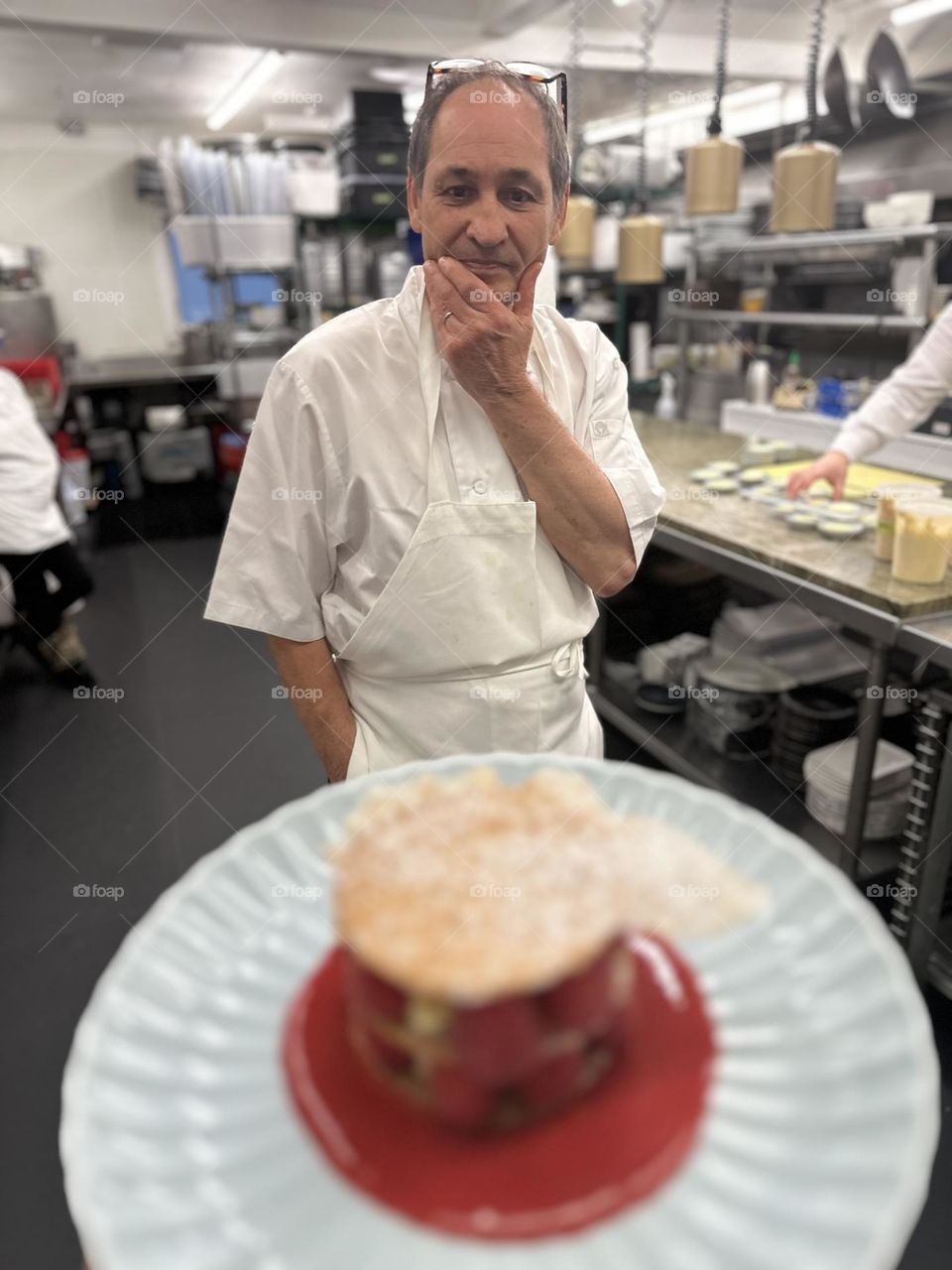 Executive chef views a plate before it is served to patrons, chef’s approval, overseeing the kitchen, admiring the work of another chef, plating dinners in the kitchen, restaurant kitchens