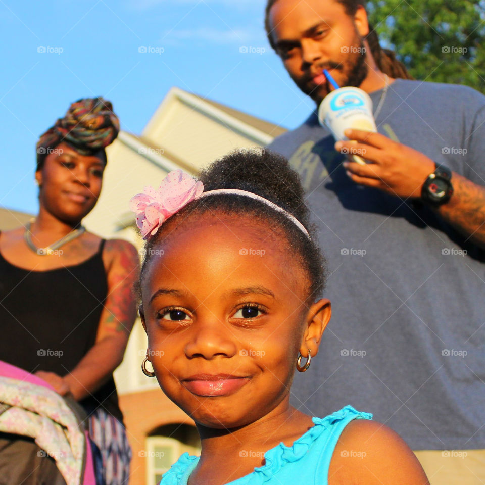 Smiling child with parents in the background