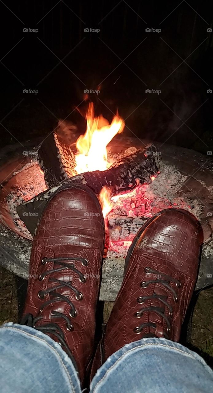 shoes boots in front of a fire bonfire