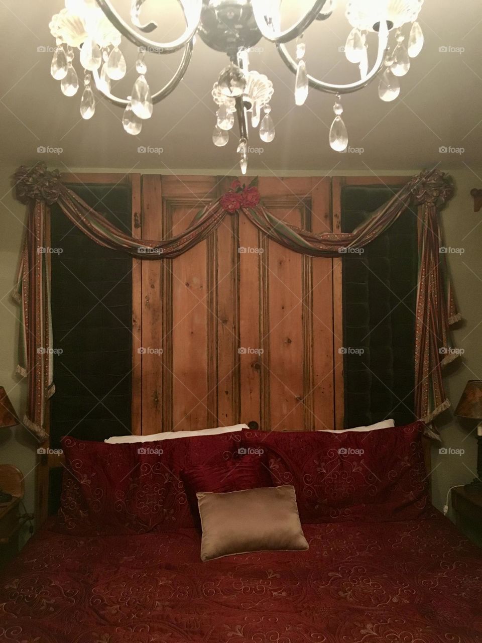 A bedroom in a charming old bed and breakfast on Prince Edward Island, Canada, where time seems to slow down. A beautiful chandelier hangs from the ceiling, shimmering glow across the room. The the room feels like a step back in time-a vintage allure